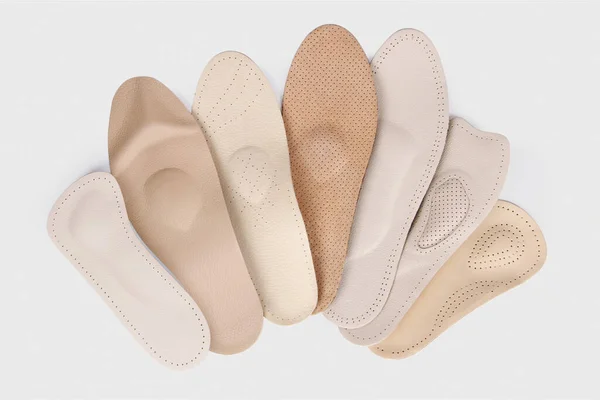 Beyaz arka planda izole edilmiş ortopedik taban. Düz taban ve ayak hastalıklarının tedavisi ve önlenmesi. Ayak bakımı, ayaklara iyi gelir. Rahat ayakkabılar giy. Tıbbi tabanlar. Düz Ayak Düzeltme.