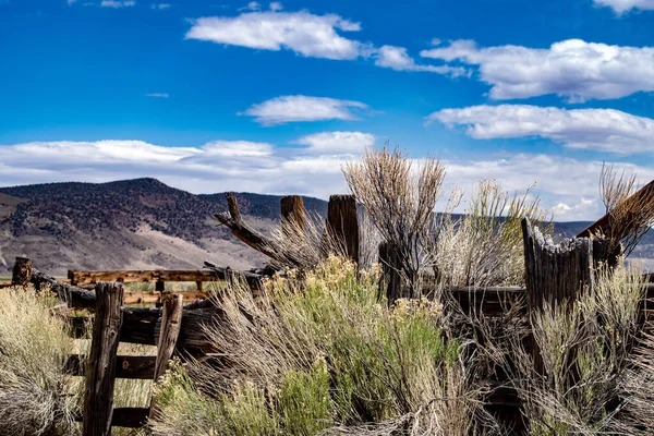Adobe Vadisi, Kaliforniya 'da Dobie Yolu' ndaki Red Rock Corral. Çürüyen odunlar, tepeler ve beyaz bulutlu mavi gökyüzü.