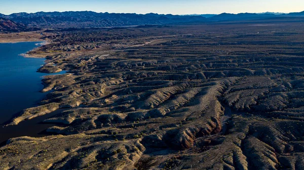 Arizona 'daki Alamo Gölü' nün insansız hava aracı görüntüsü Bill Williams Nehri üzerinde açık mavi gökyüzü ve su, kahverengi tepeler ve mor dağlar ve güzel çöl manzarası.
