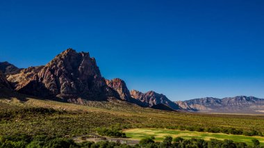 Bahar Dağı Parkı, Nevada, Ekim 'de kızıl kaya, yeşil bitki örtüsü ve mavi gökyüzü