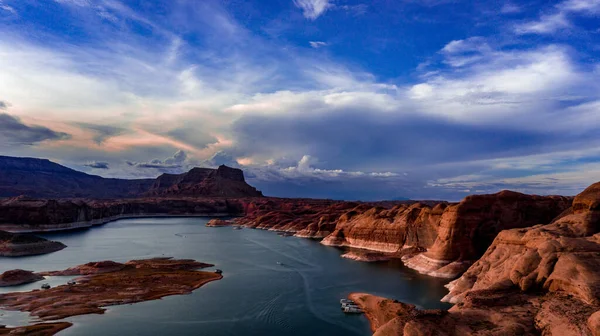 Havadan, panoramik, Utah ve Arizona 'daki güzel Powell Gölü manzarası. Muson mevsiminde, kırmızı kaya tepeleri, mavi su ve gökyüzü, su yansımaları, San Juan Nehri yakınlarındaki beyaz ve gri bulutlar.