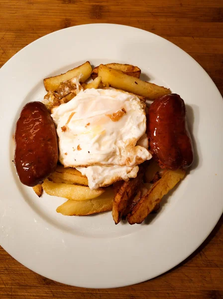 Başka bir bakış açısıyla kırık yumurta, sucuk ve kızarmış patates. Tipik bir İspanyol yemeği.
