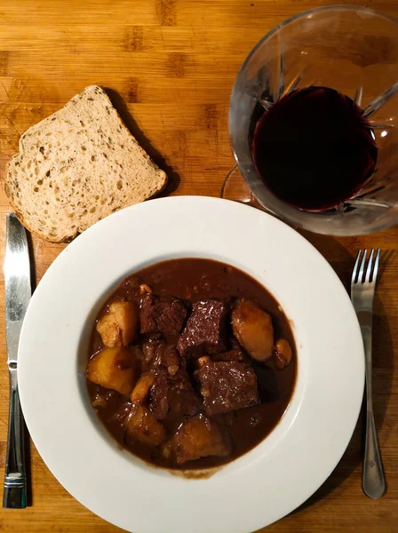 Çikolata ve patatesle yapılmış sığır güveci ve bir bardak Pedro Jimenez 'in şarabı ve tohum ekmeği.