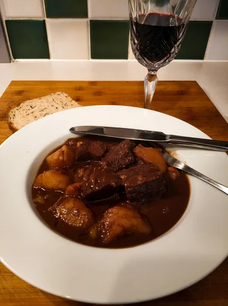 Çikolata ve patatesle yapılmış sığır güveci ve bir bardak Pedro Jimenez 'in şarabı ve tohum ekmeği.