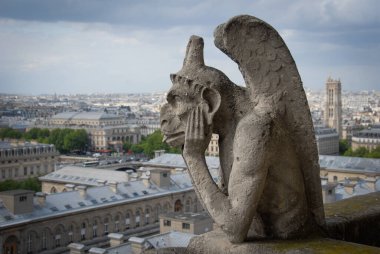 Gargoyle Notre Dame 'ın tepesini düşünüyor.