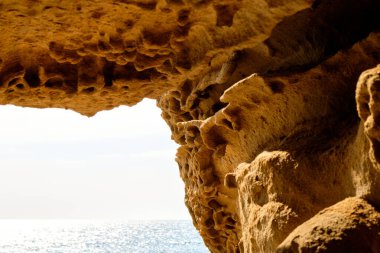 Kum taşı mağarasından denize doğru bir manzara. Kum taşı dokusu arkaplanı, doğal yüzey.