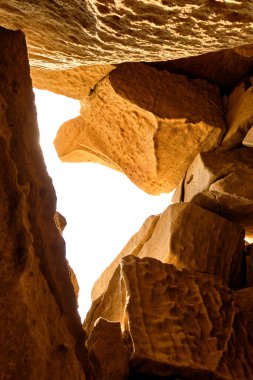 Güneşin doğuşuyla aydınlanan küçük bir kaya mağarası. Kum taşı dokusu arkaplanı, doğal yüzey.