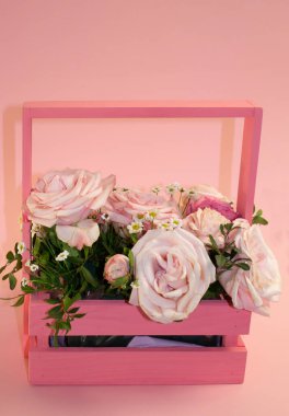 Kartpostal şablonu, kopya sprey pembe arka plandaki sepetteki pembe güller.