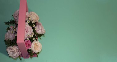 Kartpostal şablonu, kopya spesiyalleri yeşil arka plandaki sepetteki pembe güller.
