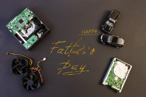 Holiday greeting card for Father\'s Day on a black background - machines, computer boards, with the text - Happy Father\'s Day