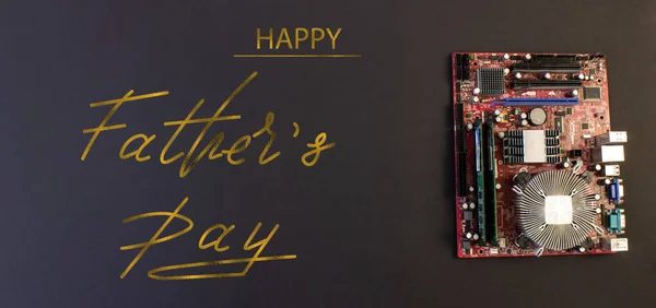 Holiday greeting card for Father's Day on a black background - machines, computer boards, with the text - Happy Father's Day
