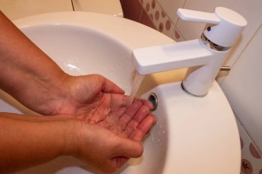 Kadın ellerini banyoda yıkıyor ve yıkıyor.