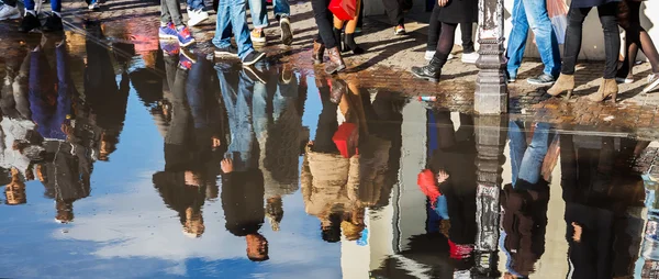 Multitud de personas reflexionando en un charco —  Fotos de Stock