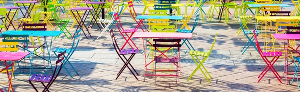 Platz gefüllt mit bunten Tischen und Stühlen — Stockfoto