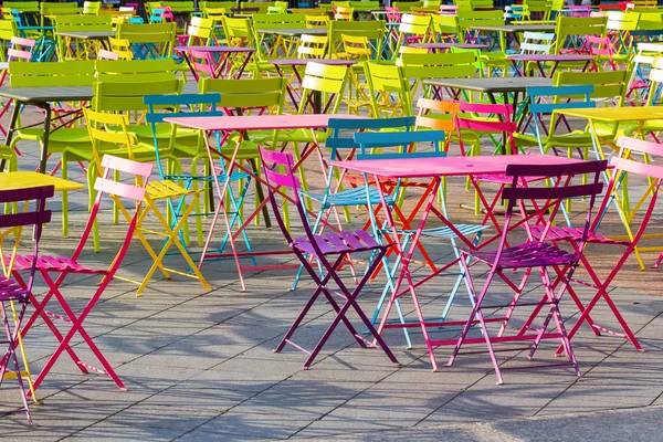 Quadrado cheio de mesas coloridas e cadeiras — Fotografia de Stock