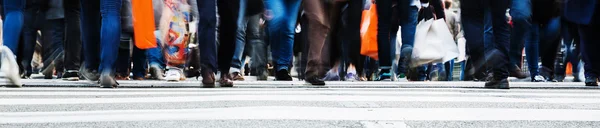 Menschenmenge überquert eine Straße in der Stadt — Stockfoto