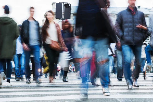 Multitud de personas cruzando una calle de la ciudad — Foto de Stock