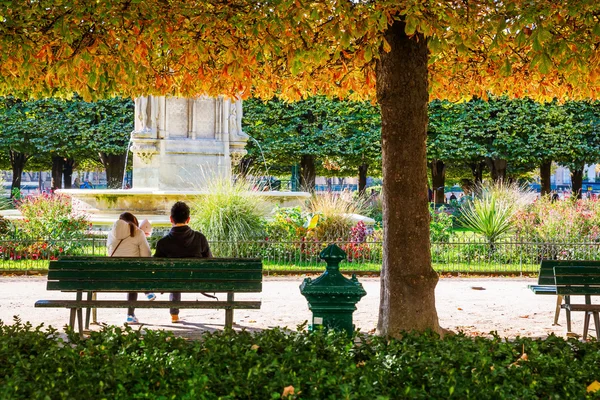 Couple sitting in the park of Notre Dame of Paris — Stock Photo, Image