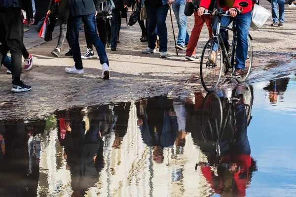 Mensen lopen in de stad weerspiegelen in een plas — Stockfoto