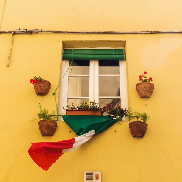 Janela de uma antiga casa italiana com bandeira — Fotografia de Stock