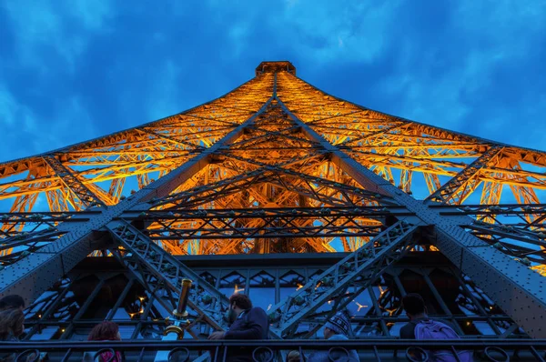 Alza lo sguardo da una delle piattaforme della illuminata Torre Eiffel a Parigi, Francia — Foto Stock