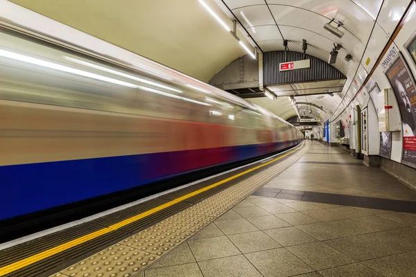 Estação de metrô de Londres com trem em borrão de movimento — Fotografia de Stock