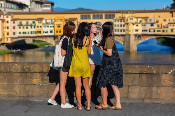 Mujeres asiáticas jóvenes tomando fotos en el Ponte Trinita en Florencia, Italia — Foto de Stock