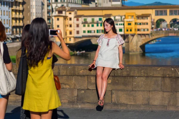 Mujeres asiáticas jóvenes tomando fotos en el Ponte Trinita en Florencia, Italia — Foto de Stock