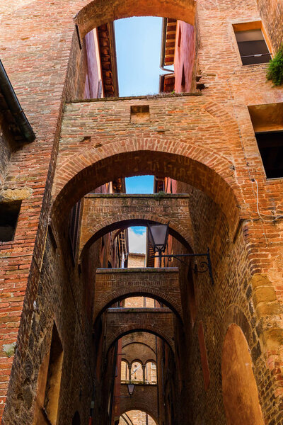 Picturesque alley with arches in Siena, Tuscany, Italy