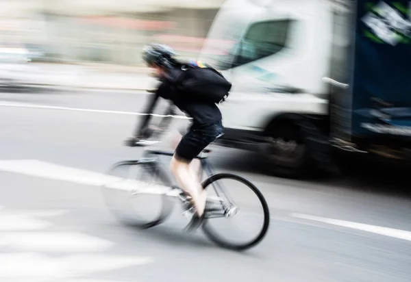 Fiets-rider in stadsverkeer met motion blur — Stockfoto