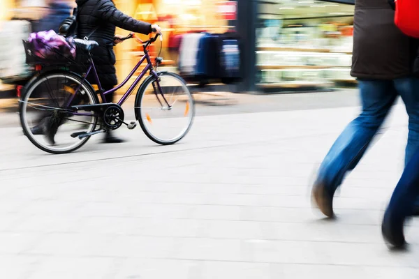 Persone a piedi e in bicicletta in città in movimento sfocatura — Foto Stock