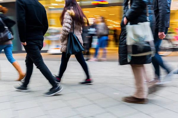 Gente caminando por la calle comercial con desenfoque de movimiento — Foto de Stock