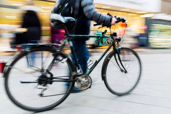 Man with bicycle on shopping street in motion blur — Stock Photo, Image