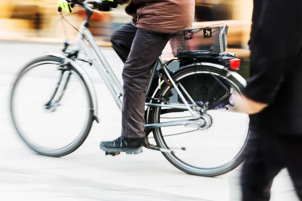 Люди прогулки и езды на велосипеде в городе в движении размытие — стоковое фото