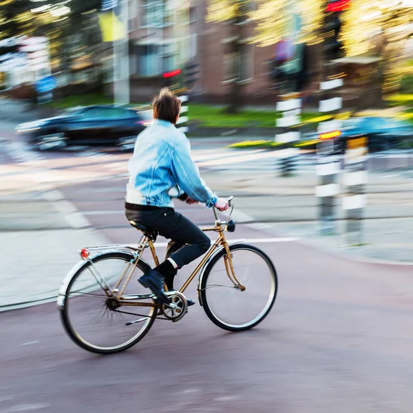 Fiets rider in stadsverkeer in motion blur — Stockfoto