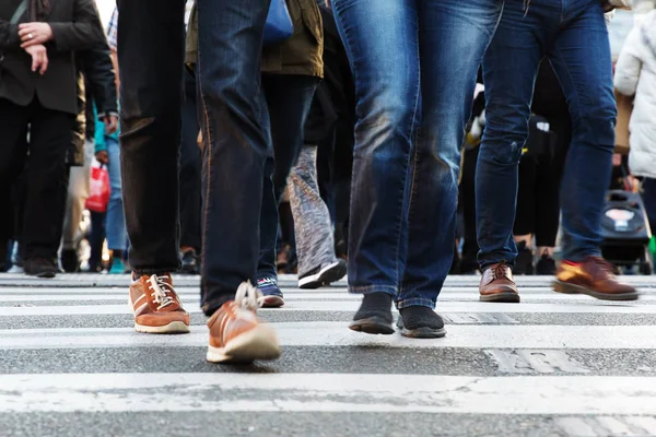 Pernas de pessoas que cruzam uma rua — Fotografia de Stock