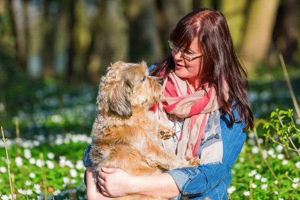 Jovem mulher e seu cão entre thimbleweeds — Fotografia de Stock