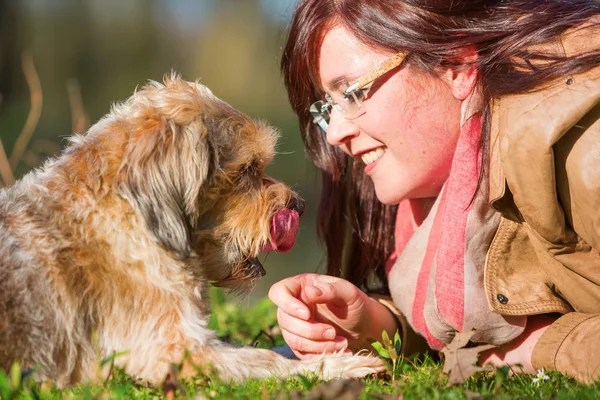 Young woman lies with her dog in the grass — Stock Photo, Image