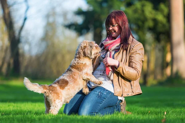 Young woman giving her dog a treat — Stock Photo, Image