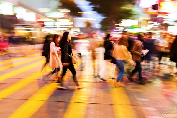 Crowds of people crossing a street at night — Stock Photo, Image