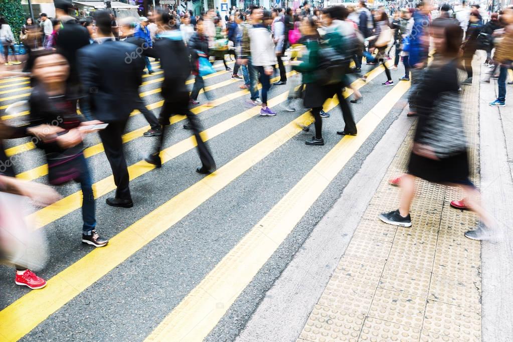 crowds of people crossing a street in Hong Kong