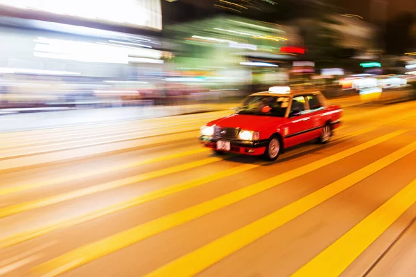 Taxi in Hong Kong in motion blur in de nacht — Stockfoto