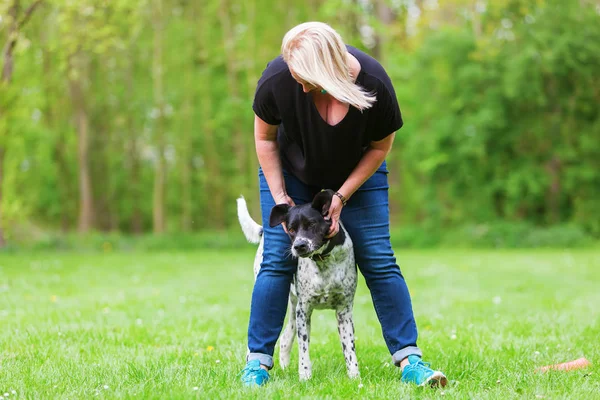 Donna gioca con il suo cane all'aperto — Foto Stock