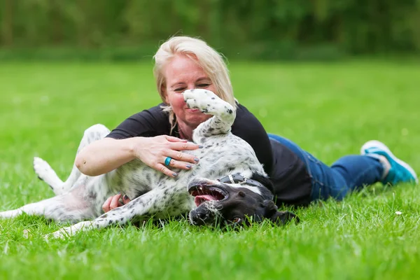 Retrato de uma mulher abraçando seu cão — Fotografia de Stock