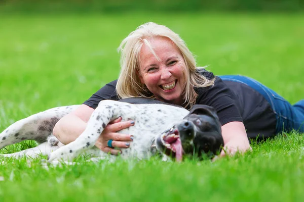 Retrato de uma mulher abraçando seu cão — Fotografia de Stock