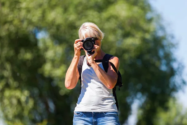 Mature woman with a camera — Stock Photo, Image