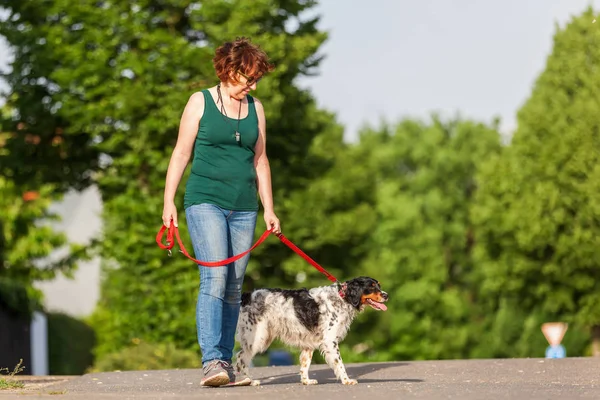 Reife Frau mit brüchigem Hund an der Leine — Stockfoto