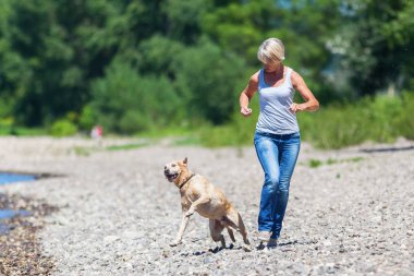 Olgun kadın ile bir köpek nehir jogs
