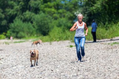 Olgun kadın ile bir köpek nehir jogs