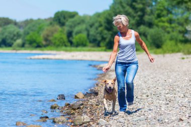 Olgun kadın ile bir köpek nehir jogs